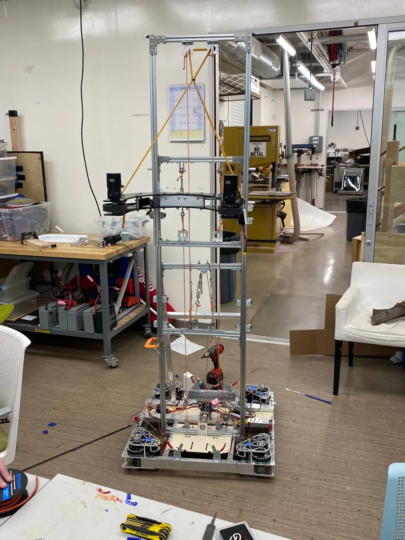 A tall robot mechanism in the shop mid-build with tools around it