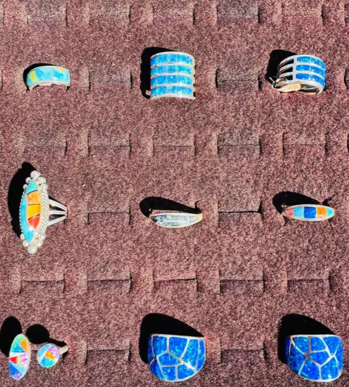 Silver rings with blue opal and multicolour stone inlay displayed on a velvet tray